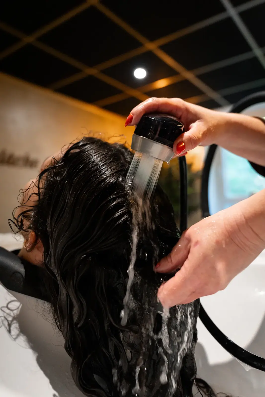 Coiffeuse lavant les cheveux d'une cliente dans un salon de beauté — Lucas Gouritin