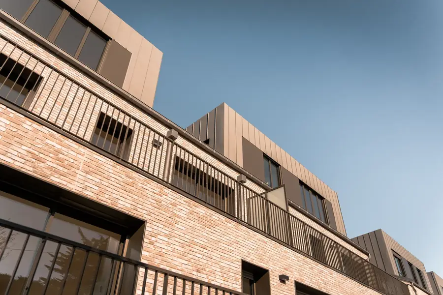 Façade moderne de bureaux ou logements en briques claires sous ciel bleu — Lucas Gouritin