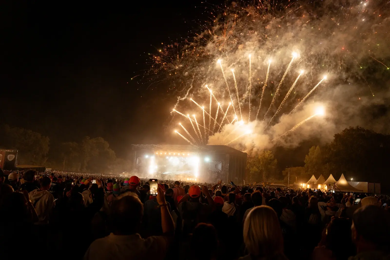 Foule au concert sous un feu d'artifice spectaculaire en soirée — Lucas Gouritin