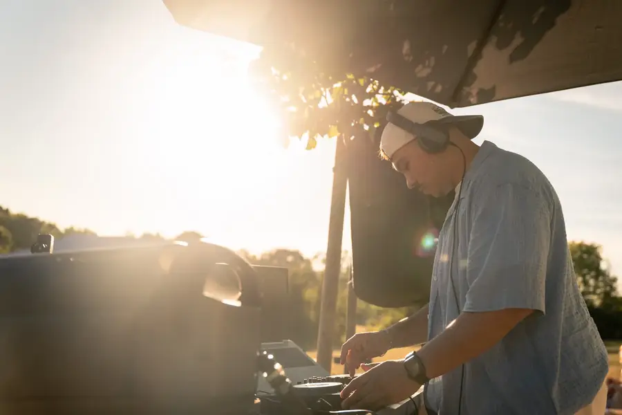 DJ mixant en extérieur avec soleil éclatant pour reportage événementiel — Lucas Gouritin