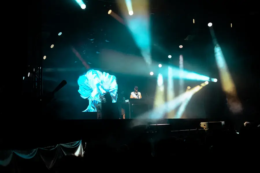 Scène de concert avec artiste DJ et projections lumineuses colorées — Lucas Gouritin