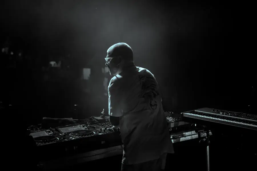 DJ illuminé par un projecteur, mixant en club pour une ambiance de concert — Lucas Gouritin