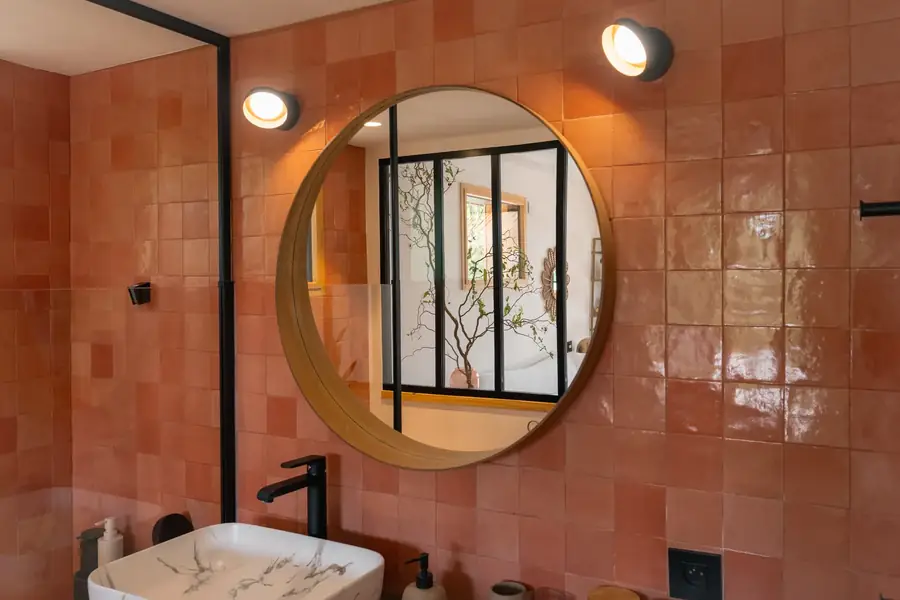 Salle de bain aux carreaux roses avec miroir rond — Lucas Gouritin