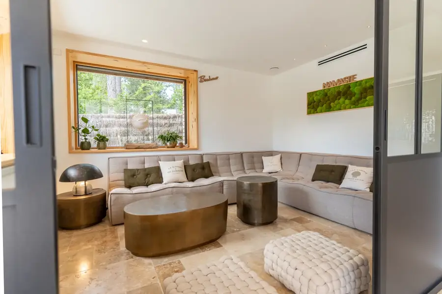 Salon lumineux moderne avec canapé d'angle gris pour agence immobilière — Lucas Gouritin