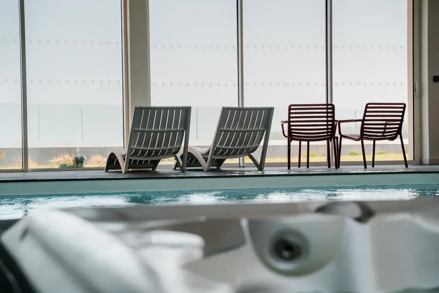 Piscine intérieure avec jacuzzi et transats pour location saisonnière en Bretagne — Lucas Gouritin